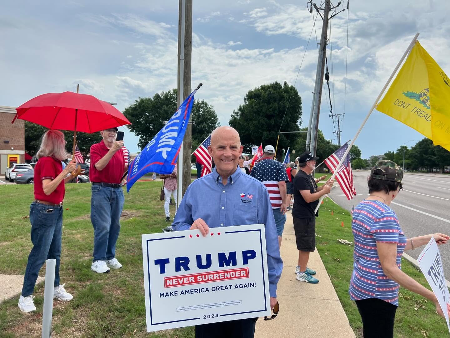 Keith Self holding a Trump Never Surrender sign at a rally